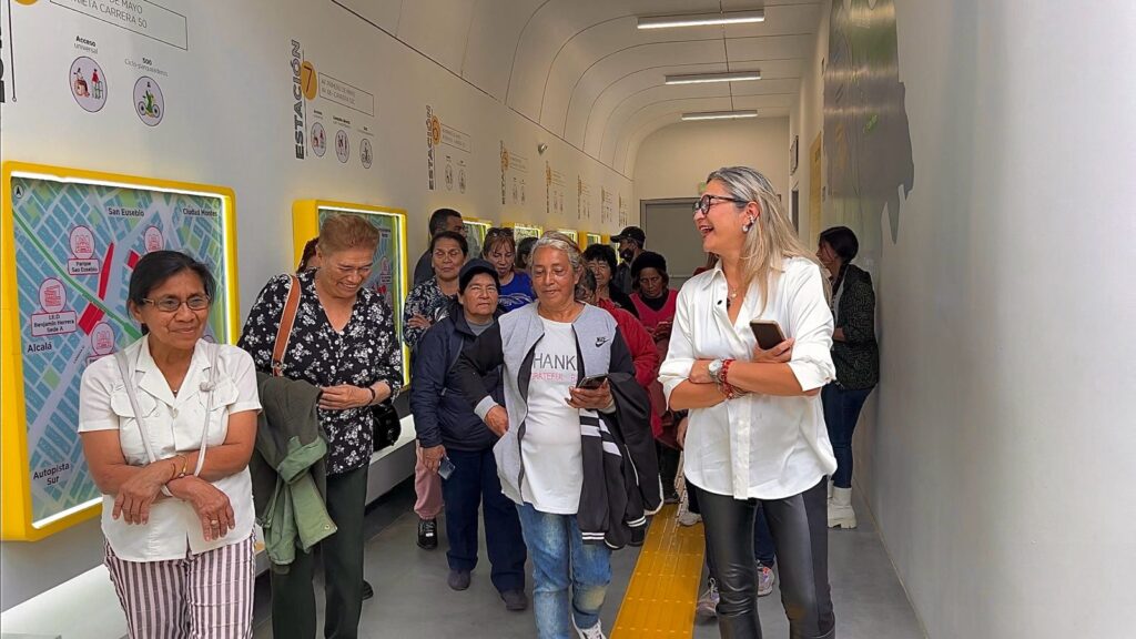 Fotografia de la comunidad de cable y buses en la Escuela Vagon del Metro junto a Carolina Martinez, Gerente de La Rolita